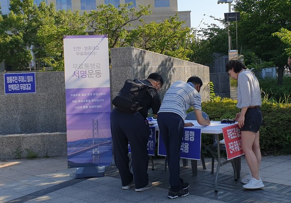 인천 대교, 영종 대교 통행료 무료화에 서명 중인 시민들